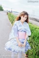 A woman in a blue and pink kimono is posing for a picture.