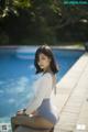 A woman sitting on the edge of a swimming pool.